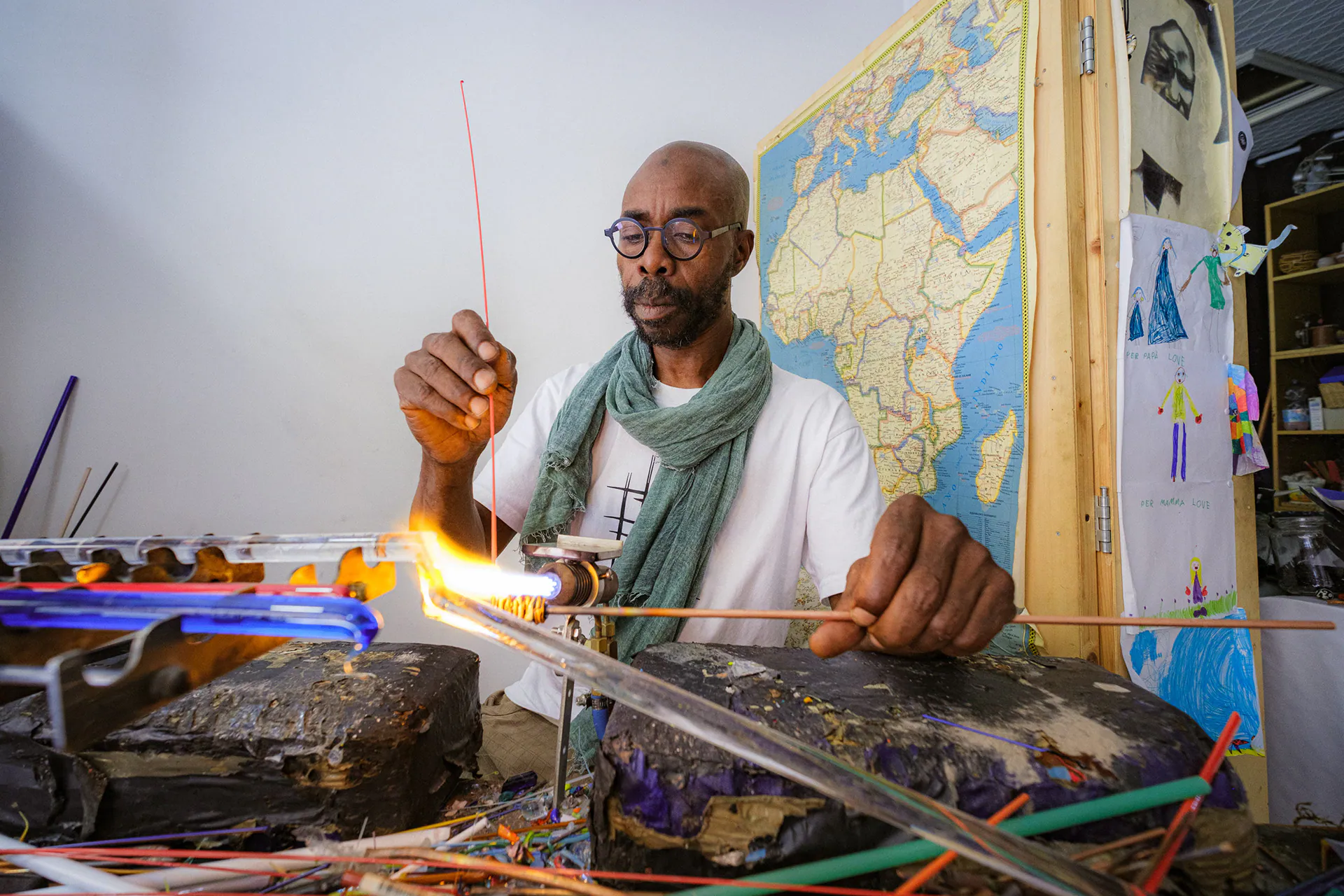 Moulaye Niang working a glass bead in his workshop