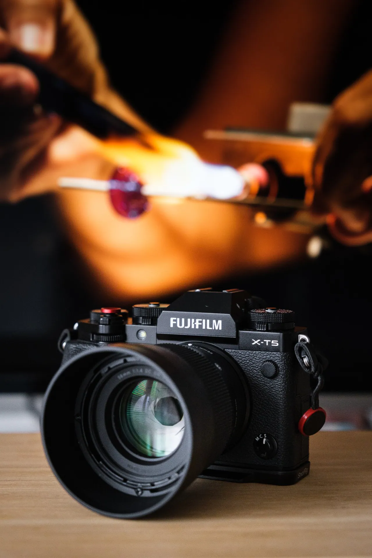 Una Fujifilm X-T5 con Sigma 56mm f/1.4 davanti a un’immagine di perle di vetro alla fiamma