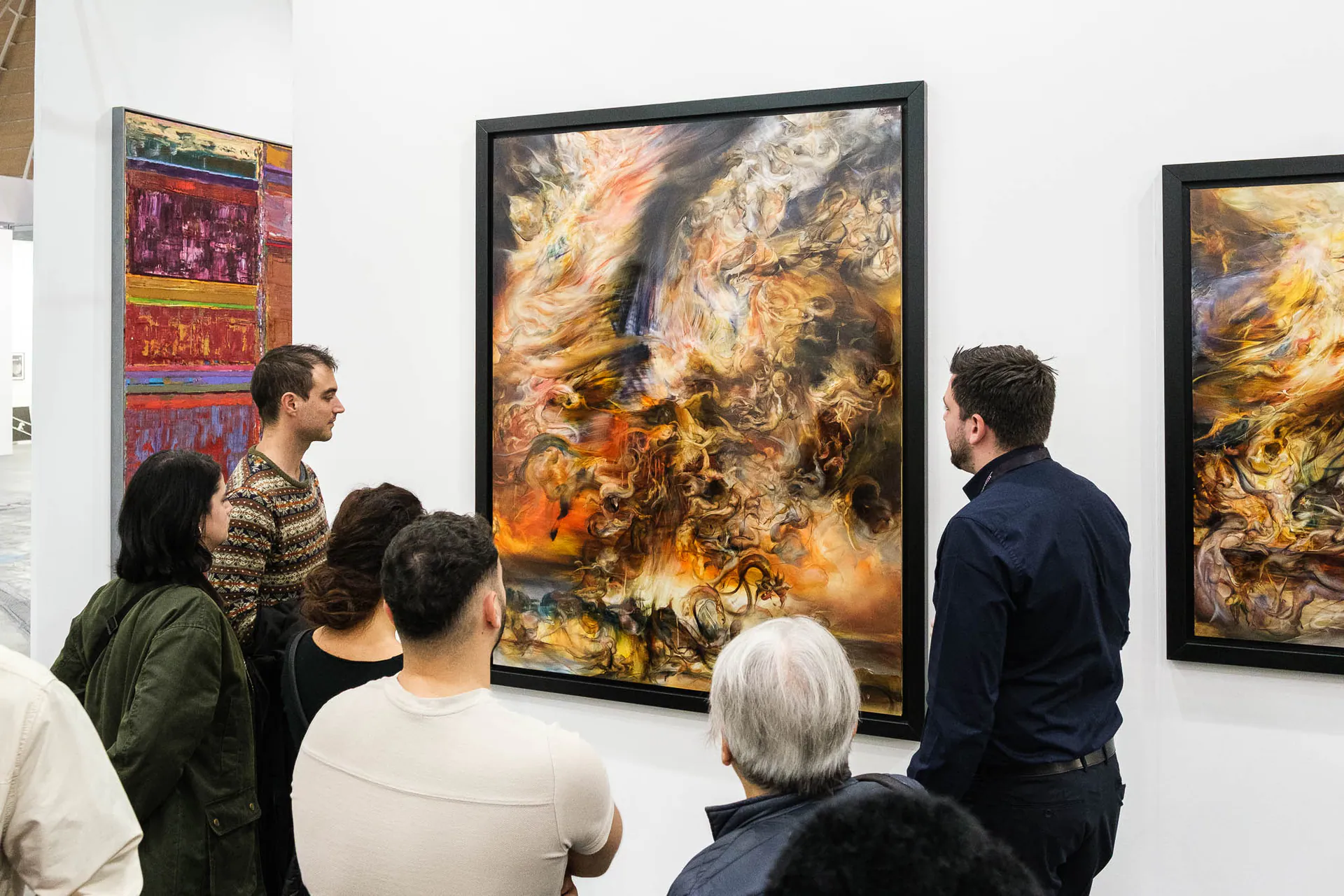 Visitors in front of a large painting at a booth of Artissima 2025.