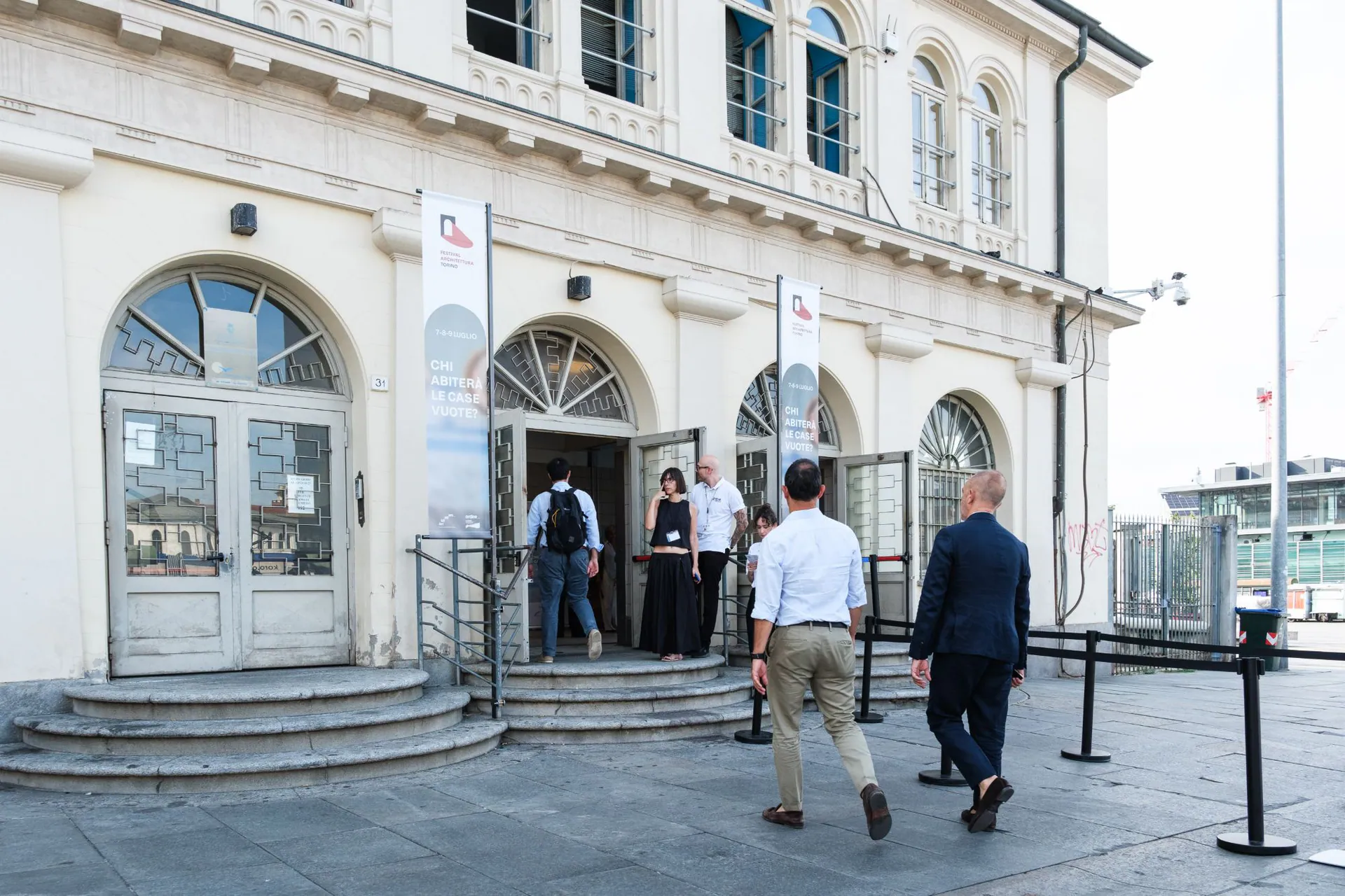 Visitors entering the Festival Architettura Torino venue, between the festival banners