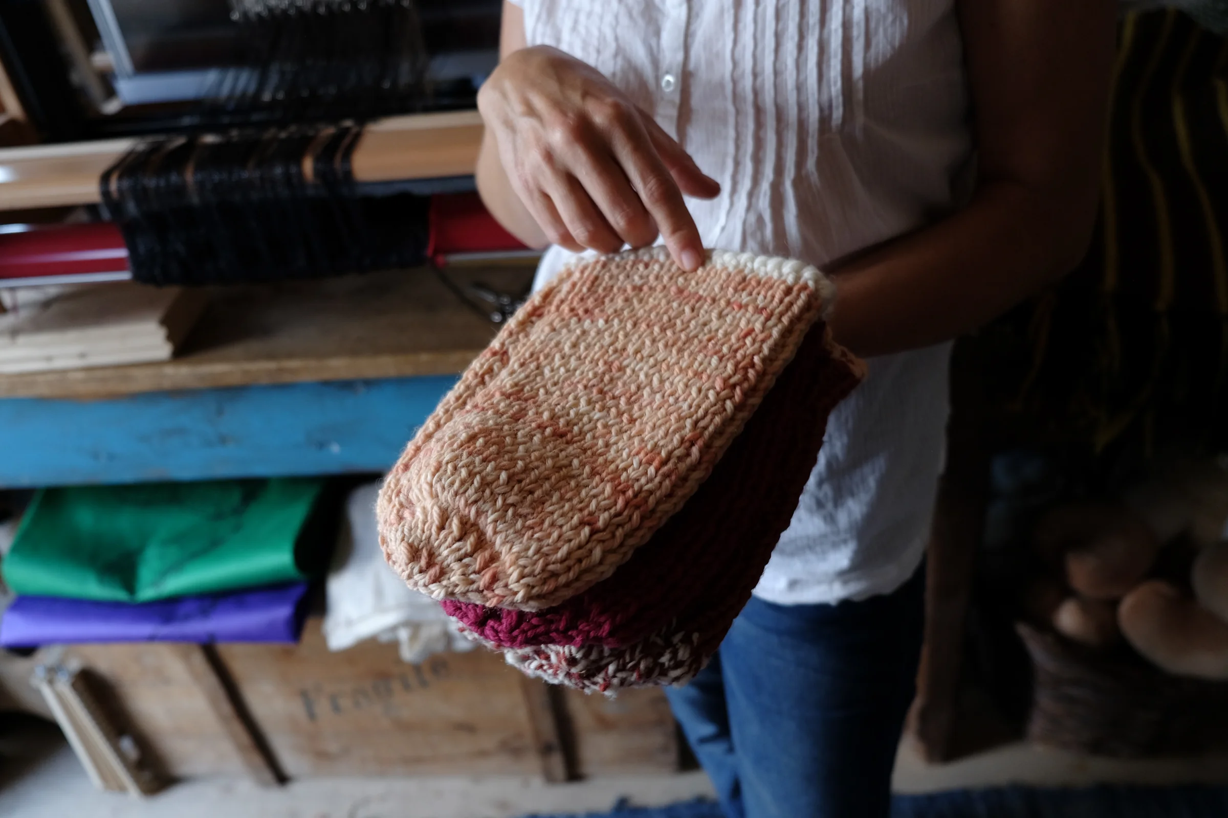 Assunta’s hands showing a hat of dyed wool