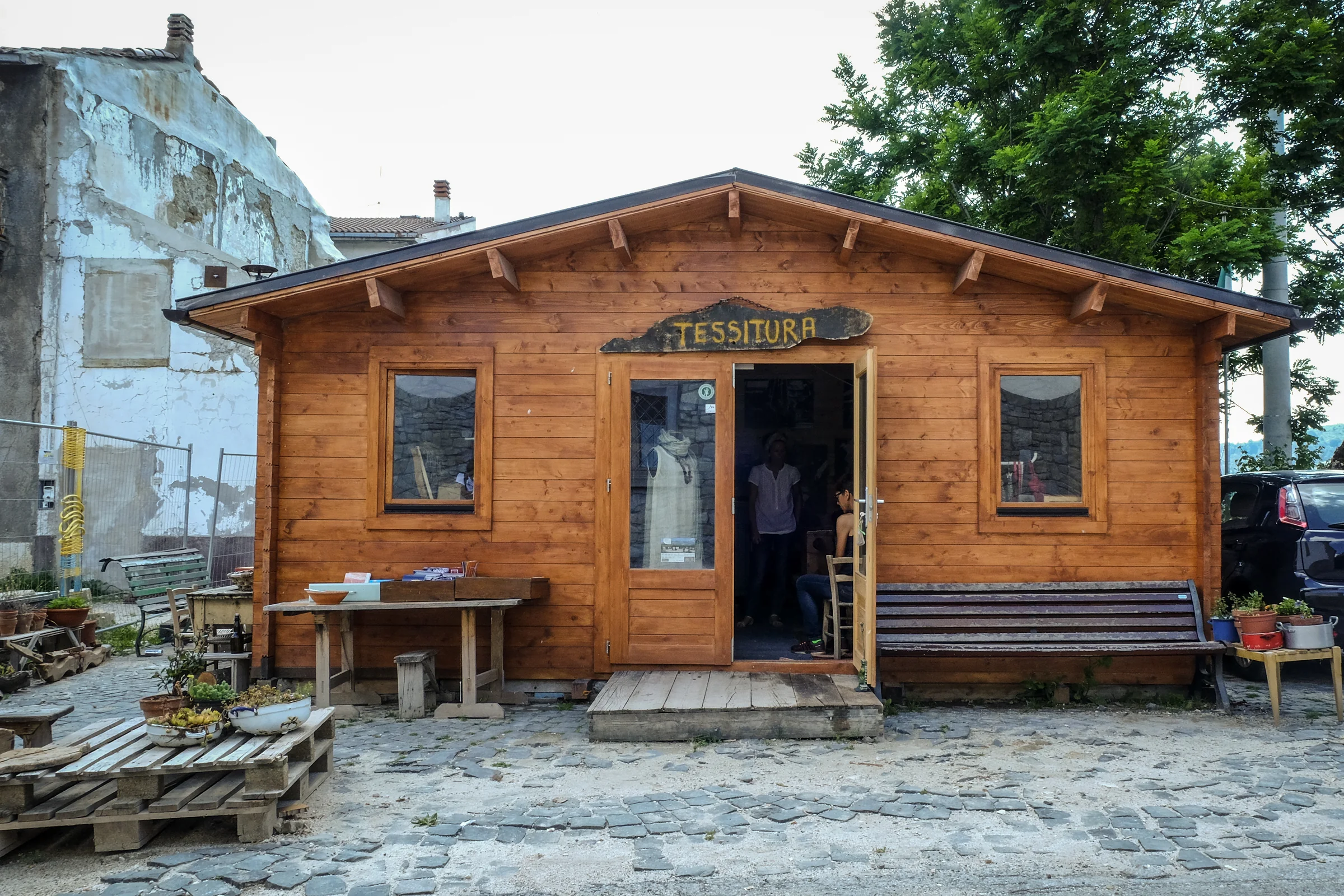 The wooden workshop with its weaving sign and the door open