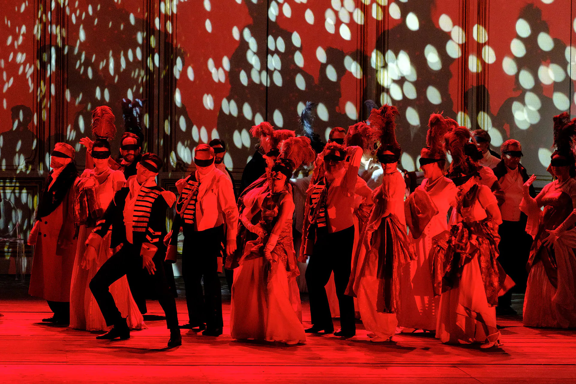 The chorus bathed in red light during the ball scene of The Queen of Spades.