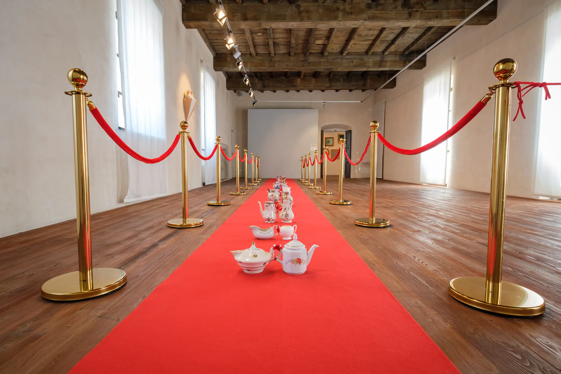 Tappeto rosso tra transenne dorate nella sala del Filatoio di Caraglio, installazione di Letizia Cariello.