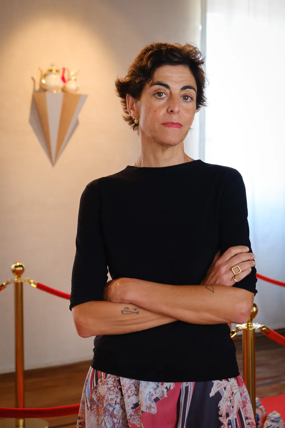 Ritratto di Letizia Cariello nella mostra, con le braccia incrociate
