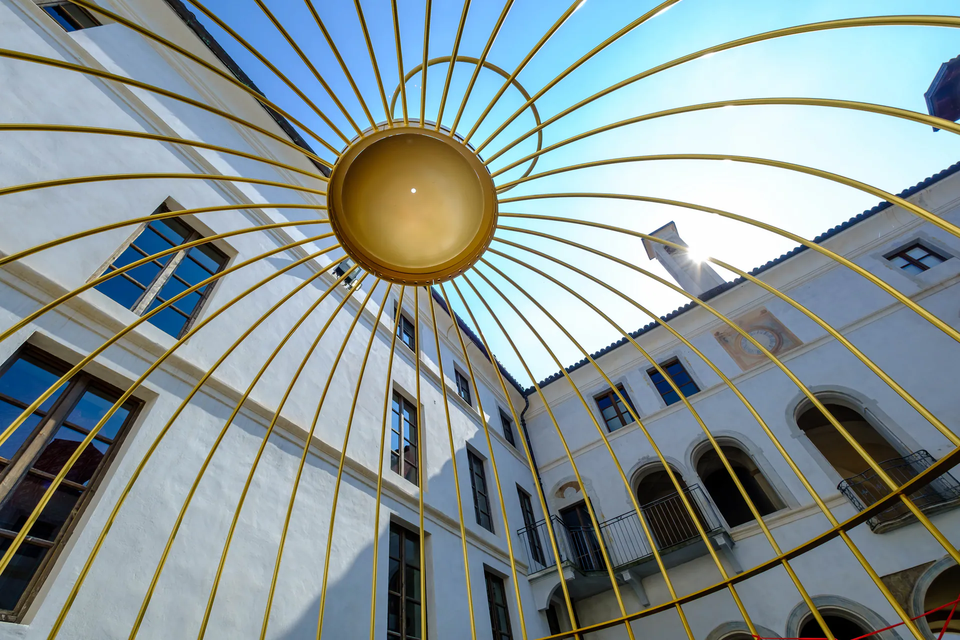 Una grande struttura dorata a raggi nel cortile del Filatoio di Caraglio, vista dal basso