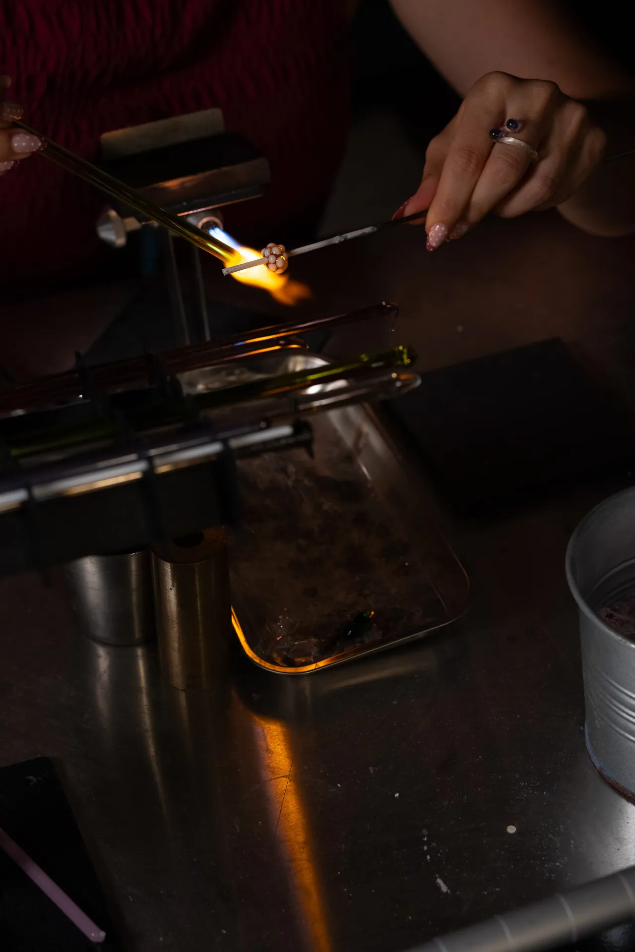 Hands decorating a bead in the flame