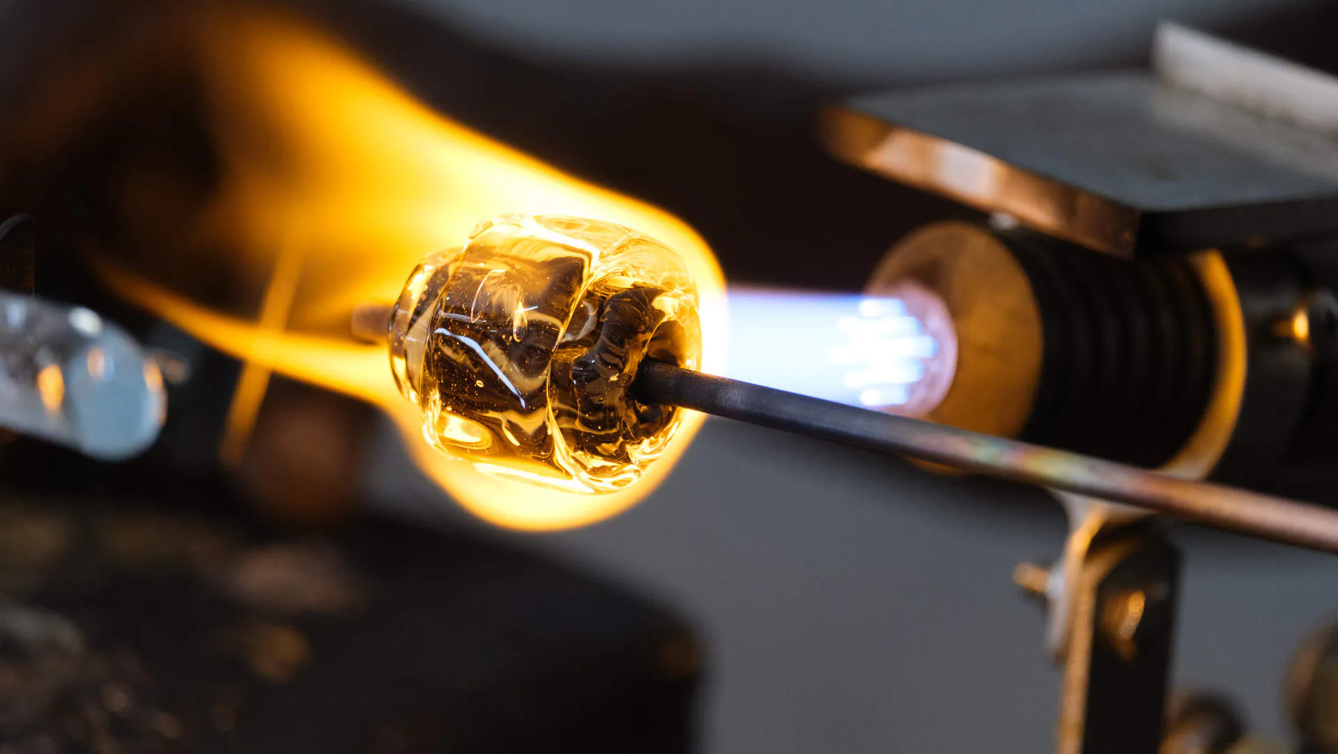 Una perla di vetro con foglia d’oro che prende forma nella fiamma