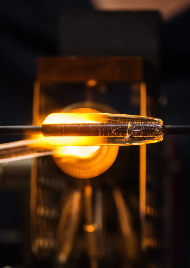 Una perla al lume, illuminata dalla fiamma in controluce