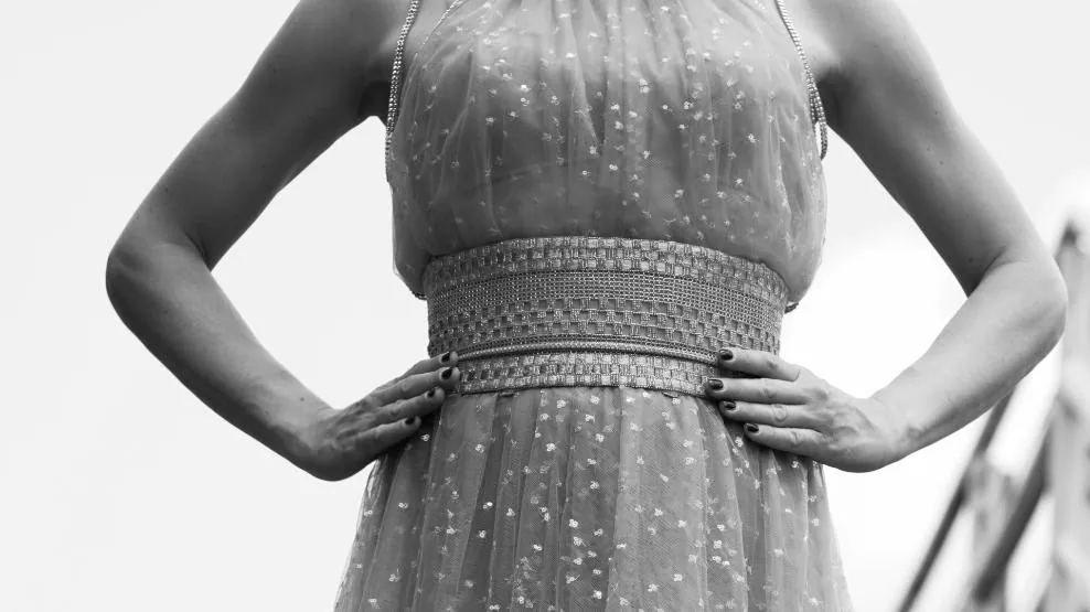 Fotogramma: dettaglio di un abito ricamato Giorgio Armani con le mani sui fianchi