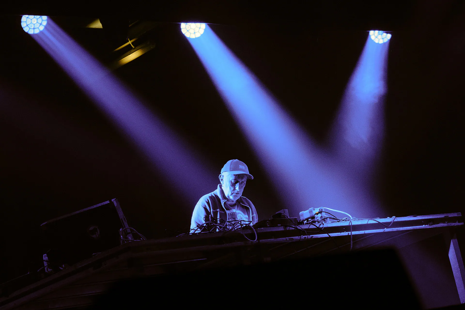 Yann Tiersen at the keyboards under beams of violet light, on stage at OGR Torino.